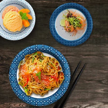 Blue patterned ultra disposable paper bowls 20 oz. filled with noodles salad and dessert on table