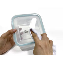 Glasslock 24-piece food storage set clear square container lid being wiped clean to remove marker and show reusable label area