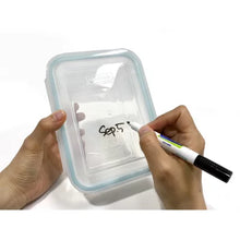 Glasslock 24-piece food storage set clear rectangular container with teal gasket held while a hand writes a date on the lid