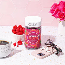 OLLY women's multivitamin gummies bottle with raspberries coffee sunglasses and pink roses on table
